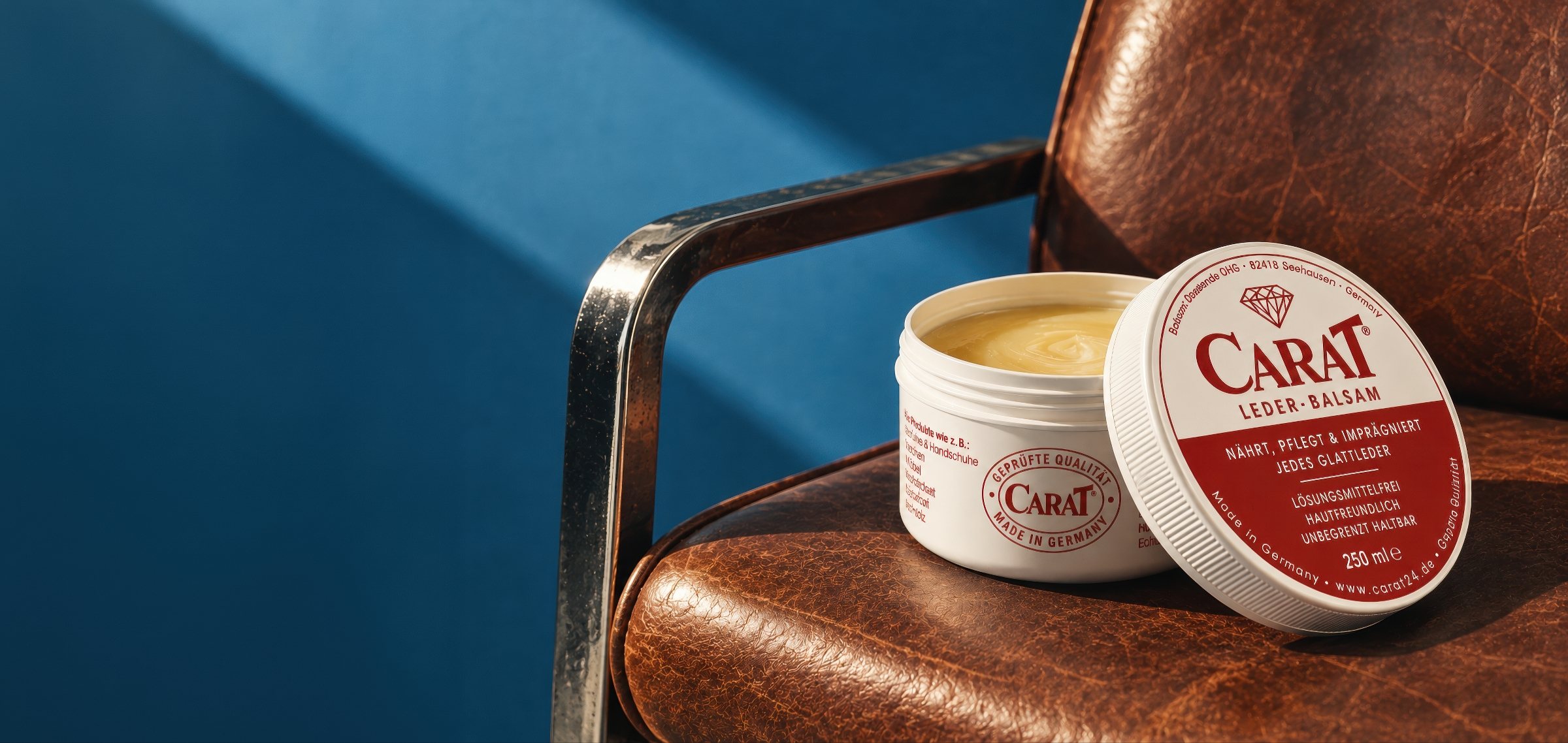 CARAT Leder-Balsam 250 ml: geöffnete Dose und aufgestellter Deckel auf einem braunen Ledersessel